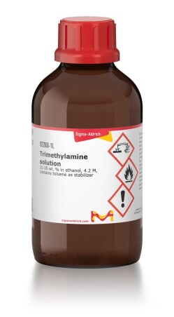 An amber glass bottle with a red lid containing Sigma brand triethylamine in a volume of 1 liter