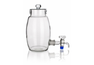 A clear glass beverage dispenser with a cylindrical body, a round lid on top, and a spigot attached to the lower side for easy pouring. The spigot is made of glass with a blue accent. The dispenser is placed against a plain white background.