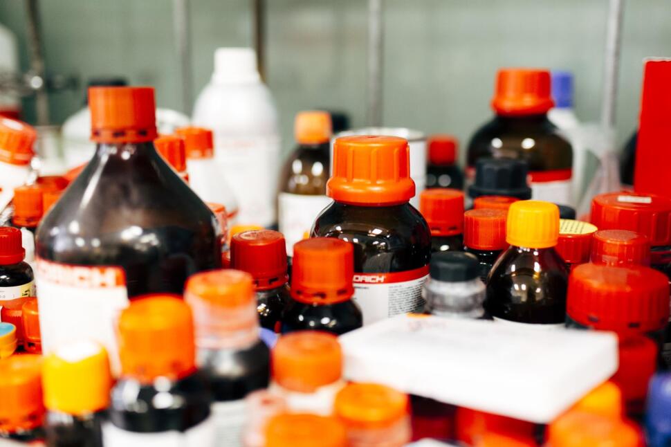 An image containing a variety of laboratory materials from the Sigma Aldrich brand. These bottles have standard red and orange lids, and inside the bottles are laboratory materials in liquid form.