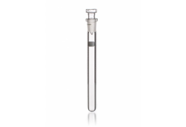 A transparent glass test tube filled with a clear liquid, sealed with a white stopper and held upright on a white surface.