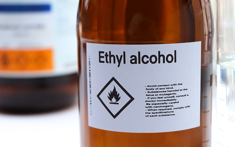 A close-up image of a laboratory substance called ethyl alcohol. This laboratory glass is in the form of Amir, and its white label contains the technical specifications of laboratory ethyl alcohol or laboratory ethanol